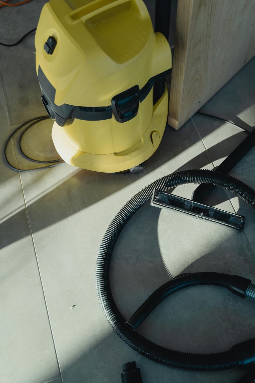 A commercial wet/dry vacuum cleaner on a tile floor